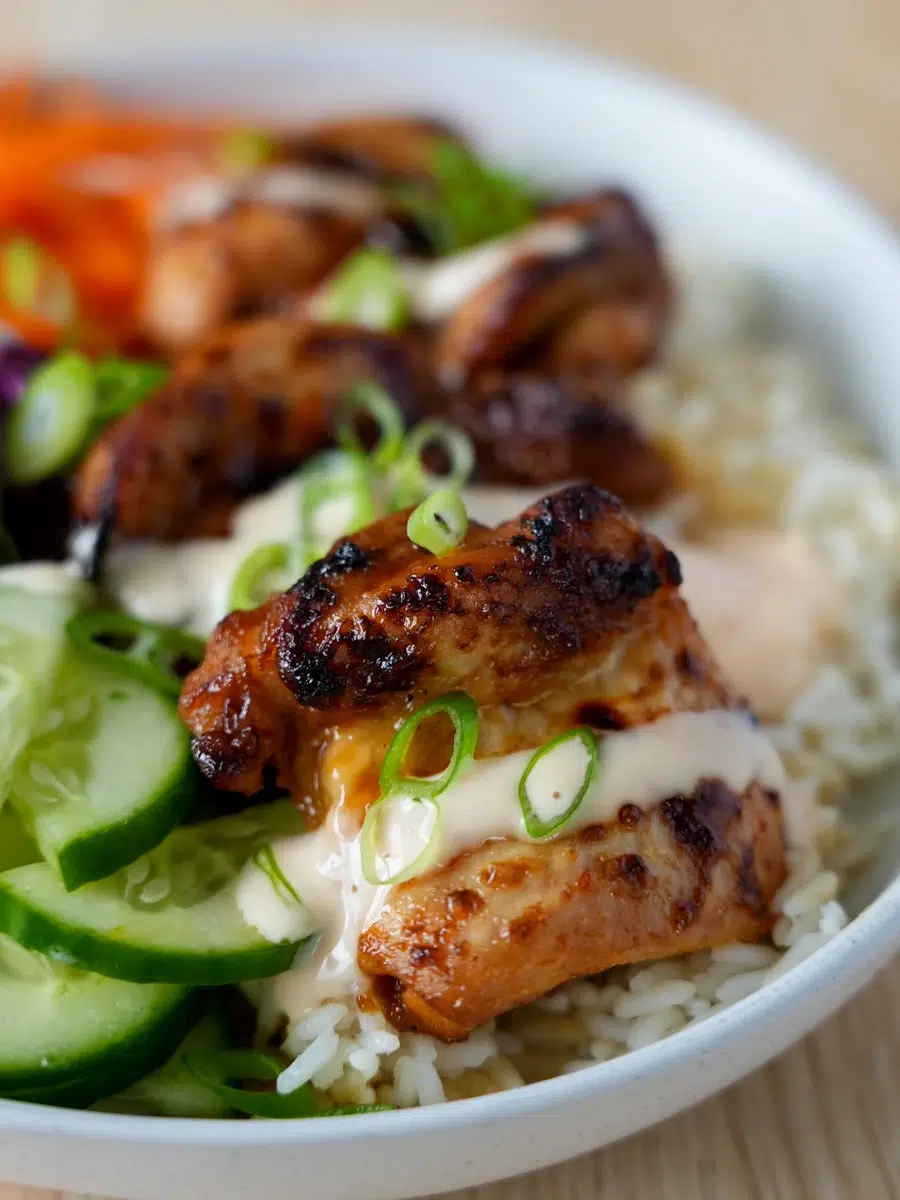 Close up of Bang Bang Chicken in a bowl with salads A bowl of Bang Bang Chicken with salads and steamed rice